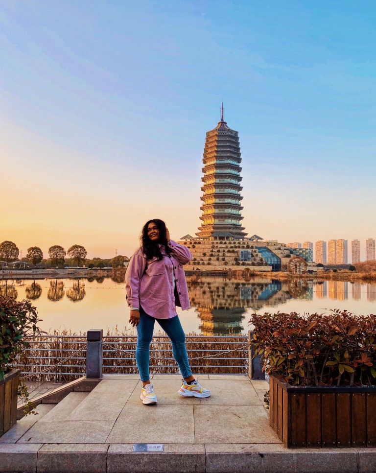 a woman posing at sunset at an impressive water museum in china