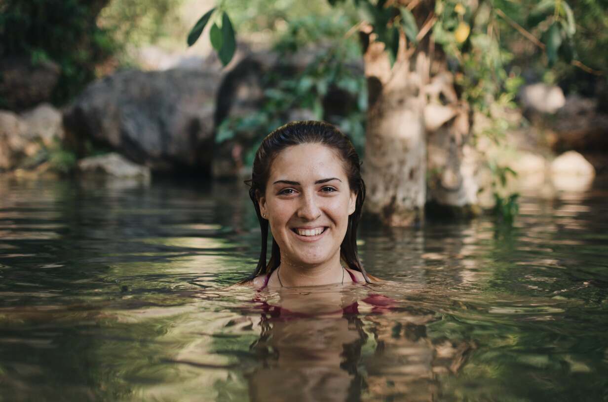 An expat woman who lives abroad in Myanmar swimming in a river