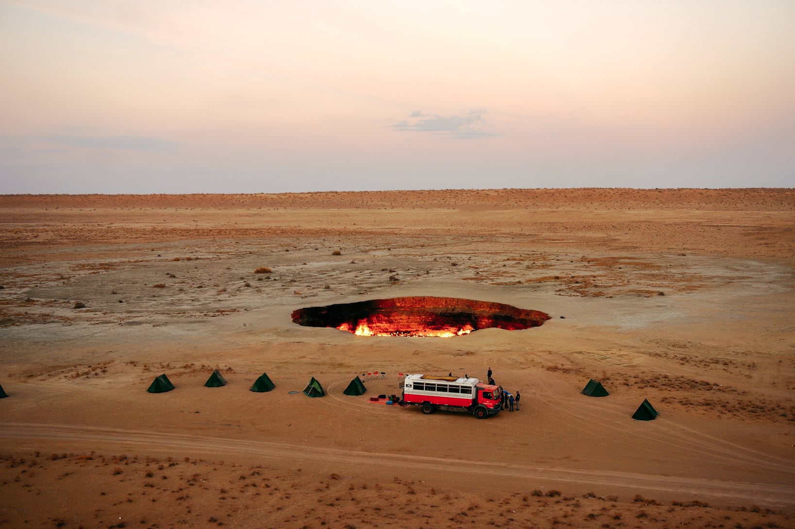 Dragoman Tour bus parked beside Darvasa gas crater in Turkmenistan