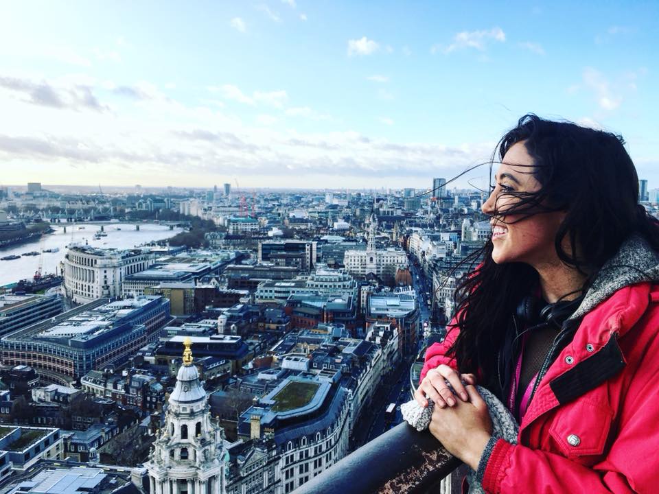 Solo female traveler enjoying her first solo trip to London from lookout point over the city