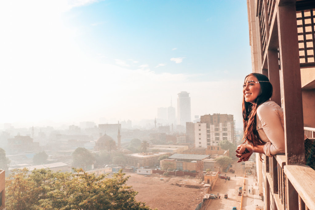 A solo female traveler on a solo trip to Egypt looking out over Cairo