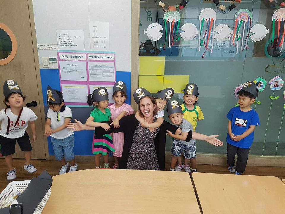 teacher getting hugs from students while in pirate hats in guri, korea