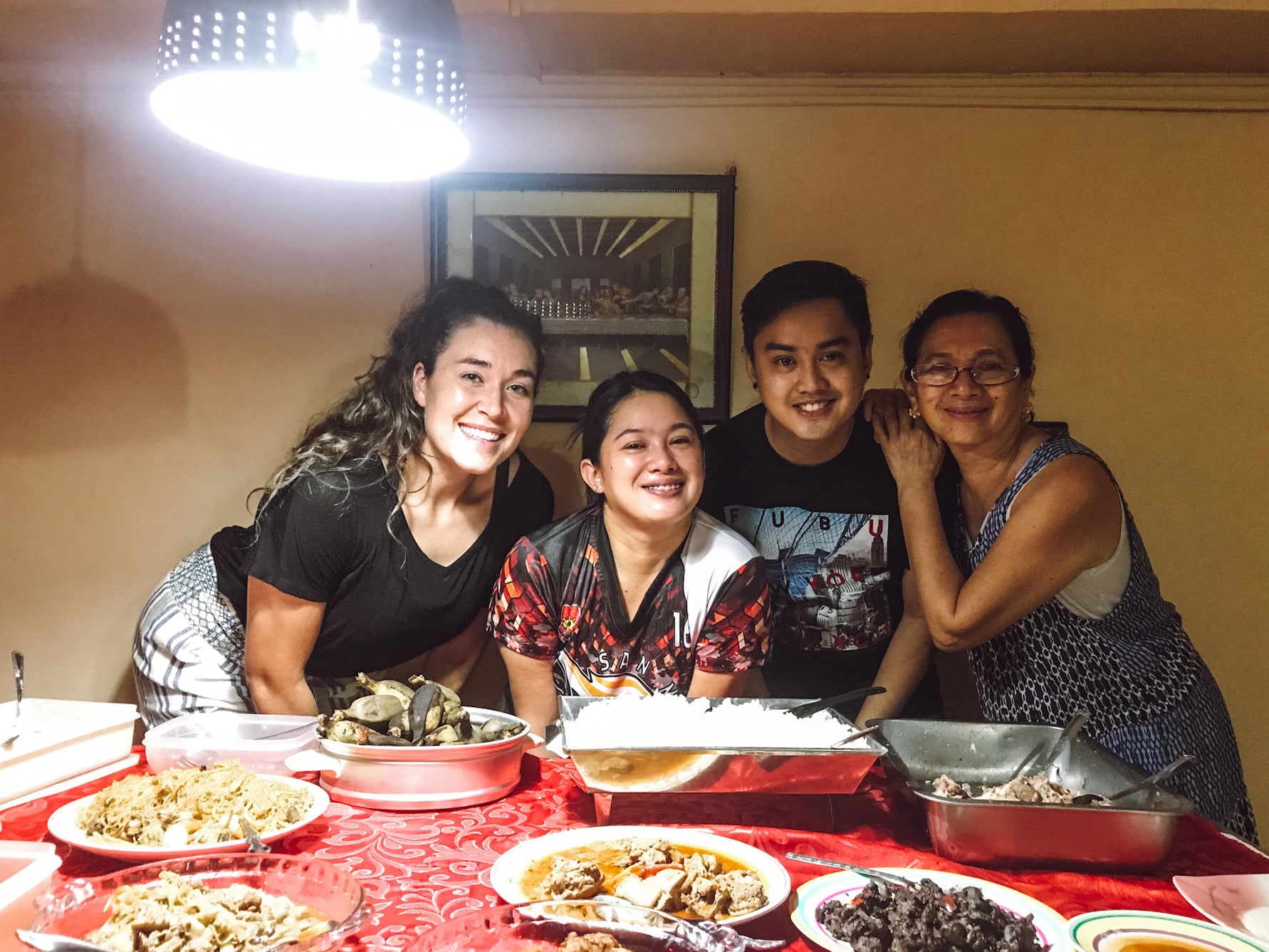 A welcoming family and a friend eating a big meal together in the Philippines