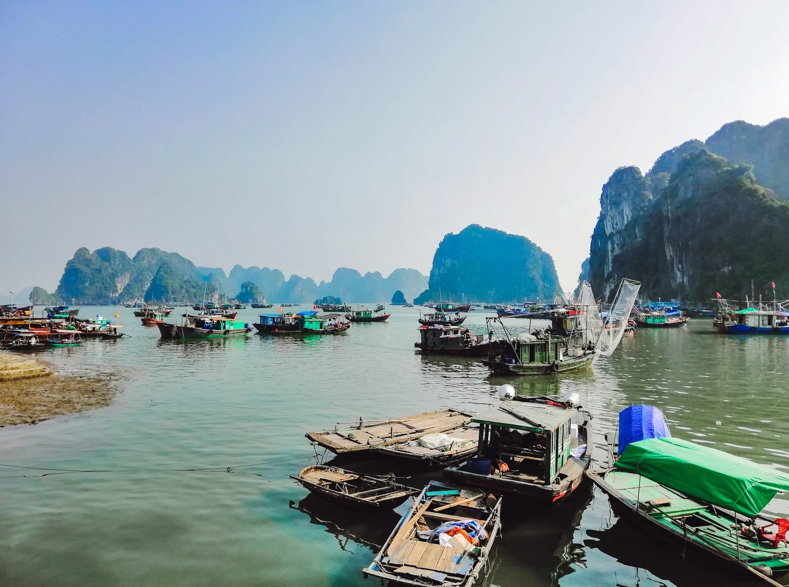 A clear afternoon in Ha Long Bay with the limestone rocks and bamboo boats