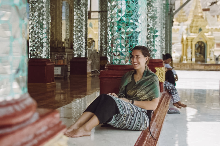 A foreign expat from Slovenia in a temple barefoot and smiling at a temple