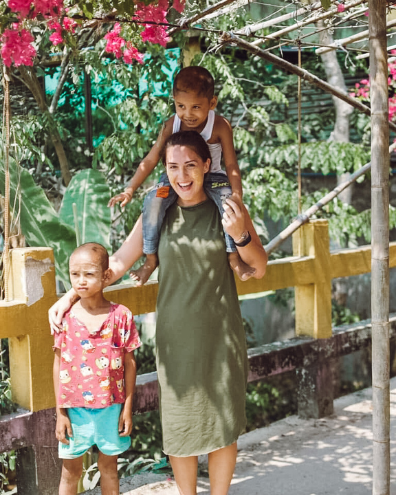 An expat teacher outside with 2 students in Myanmar