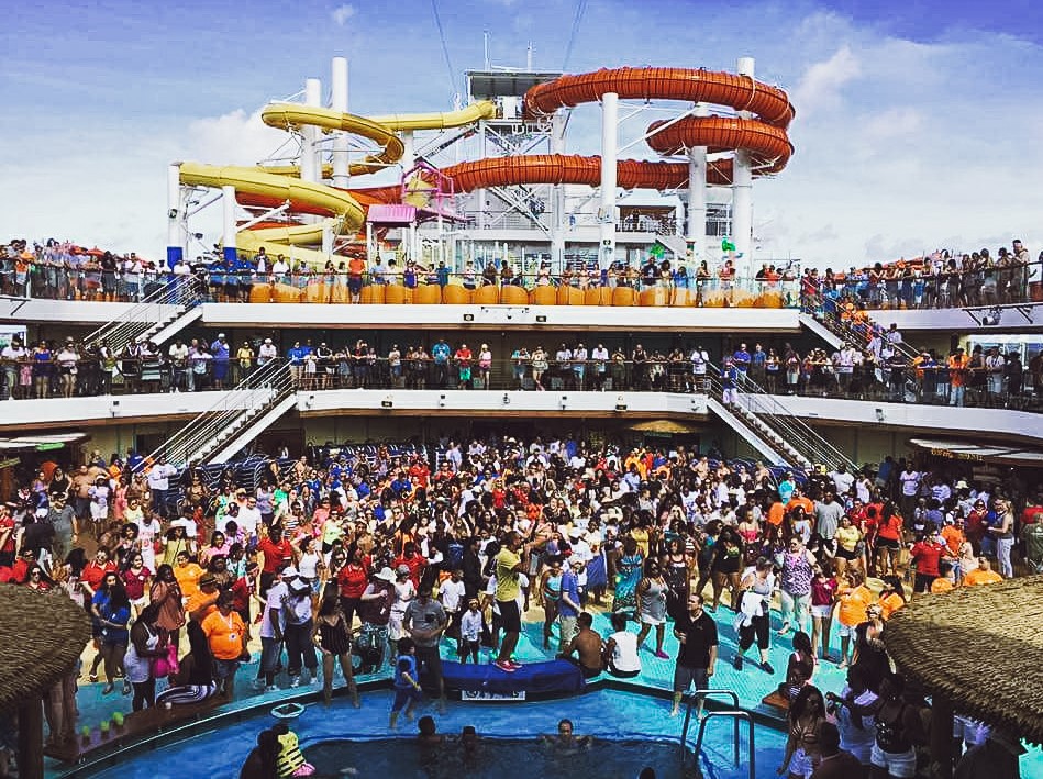 A super busy day on a cruise ship pool with thousands of people on deck together