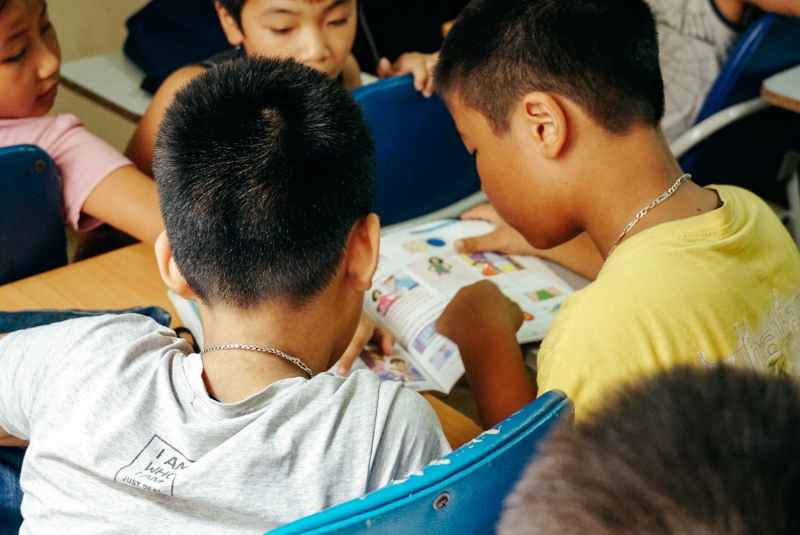 A group of students sharing a book in Vietnam