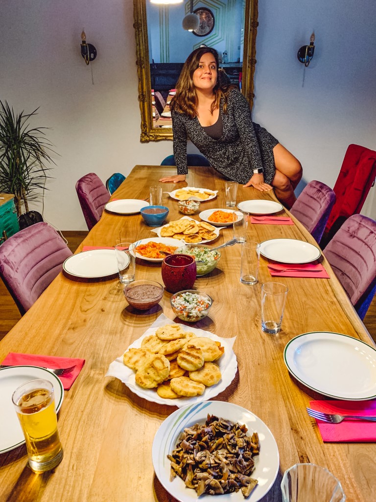 Mexican girl sitting on a table with a Mexican meal she prepared for people in Vienna, Austria