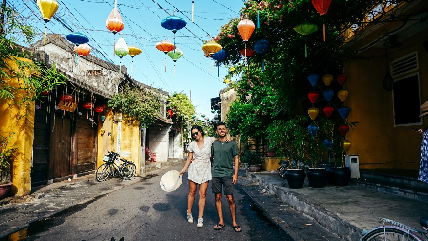 A couple posing together in a colorful, lantern street of Hoi An, Vietnam