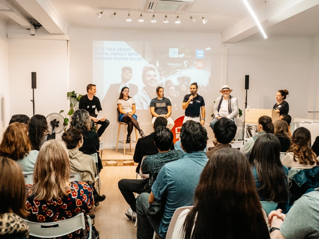 A group of speakers at a Nomads Giving Back event