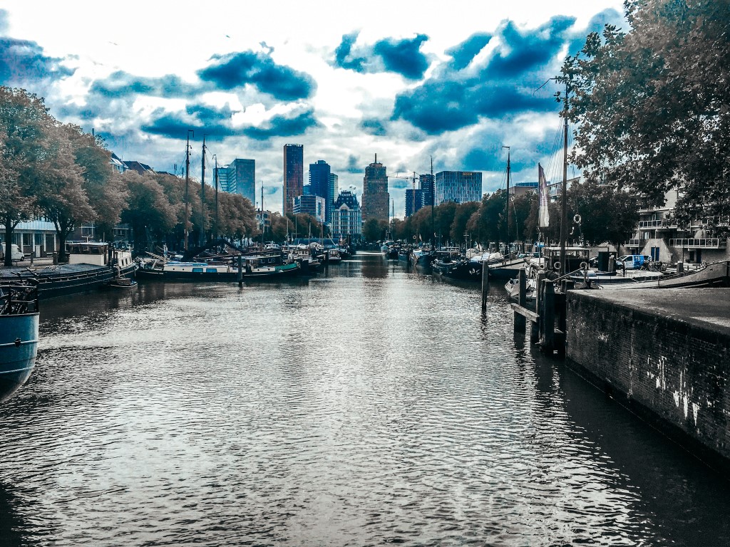 A cloudy day in Rotteram with a view of the canals but the city center in the background