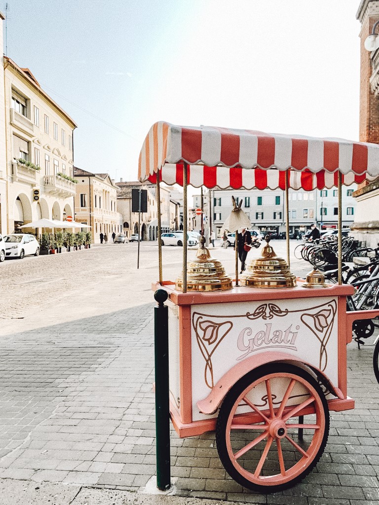 Italian aesthetic gelato cart parked in a plaza in Treviso, northern Italy on a sunny day