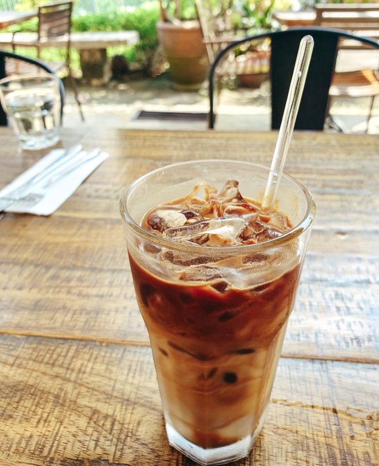 A close up of iced cham, a typical drink in malaysia, taken on an outdoor patio in kuala lumpur