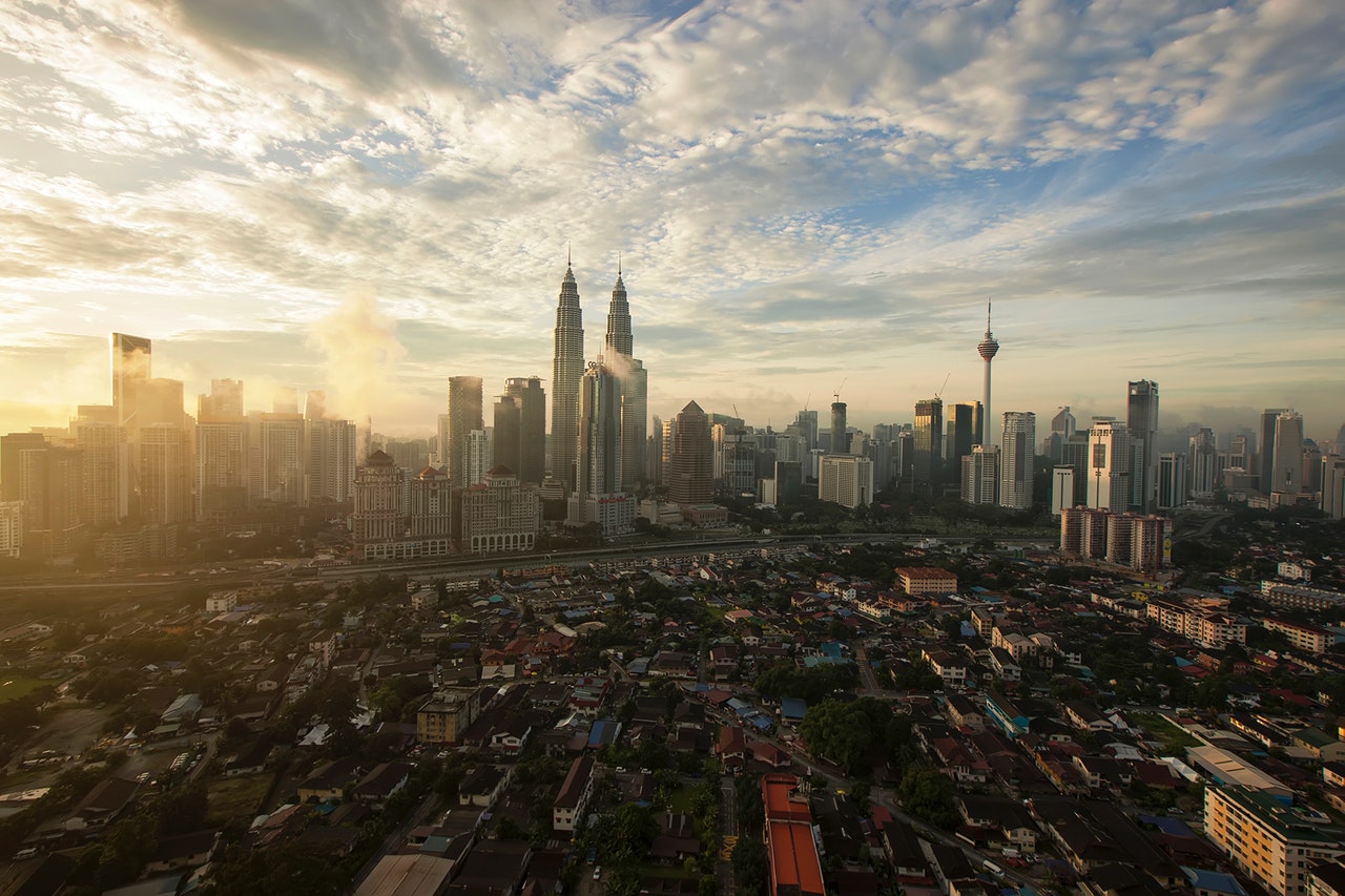 a view of Kuala Lumpur from a rooftop during sunset with the entire city in view