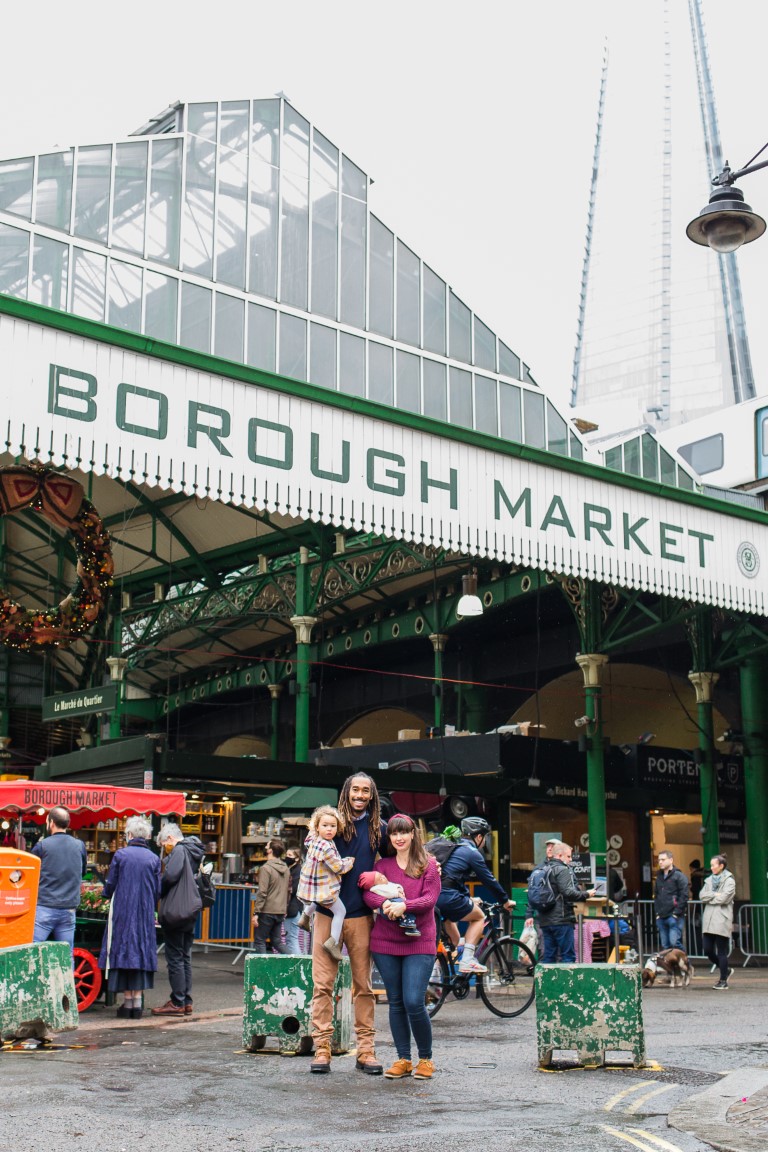smiling family standing in front of borough market in london