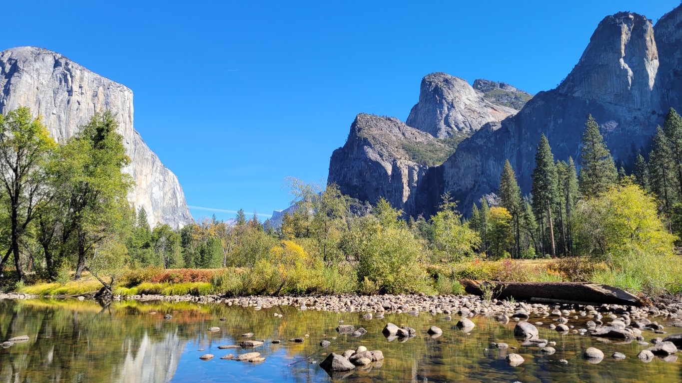A landscape photo from Yosemite National Park with El Capital and Half Dome separated by a small river