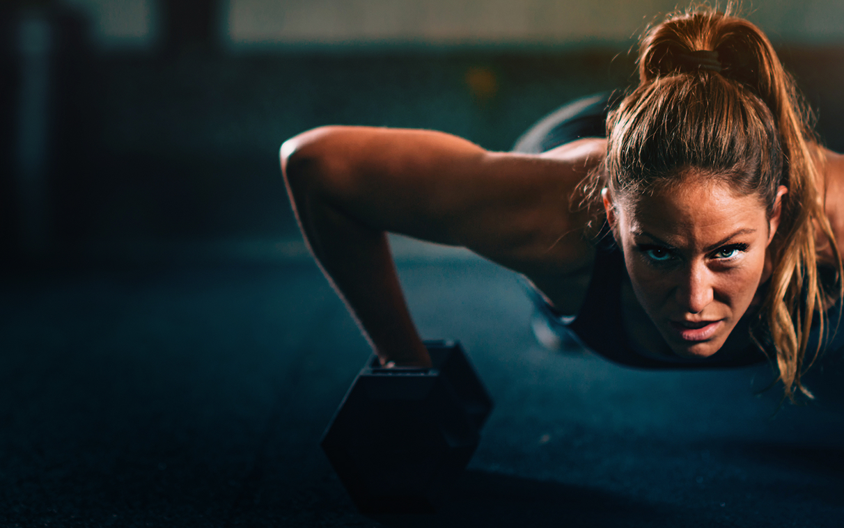 Woman at gym holding water bottle and smartphone with workout schedule showing exercises for Day 1, Day 2, and Day 3.