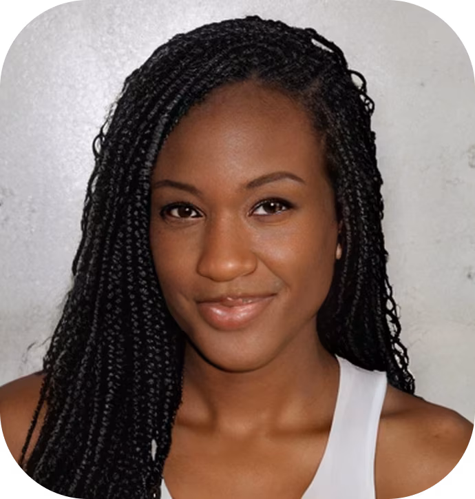 Portrait of a woman with long braided hair smiling gently, wearing a white sleeveless top against a plain light background.