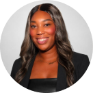 Portrait of a smiling woman with long wavy hair wearing a black top and black blazer.