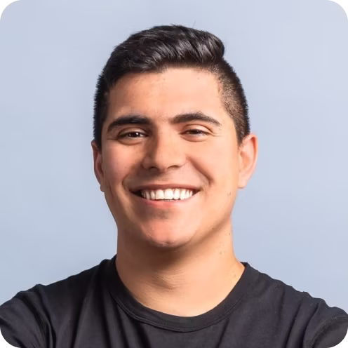 Smiling young man with short dark hair wearing a black shirt.