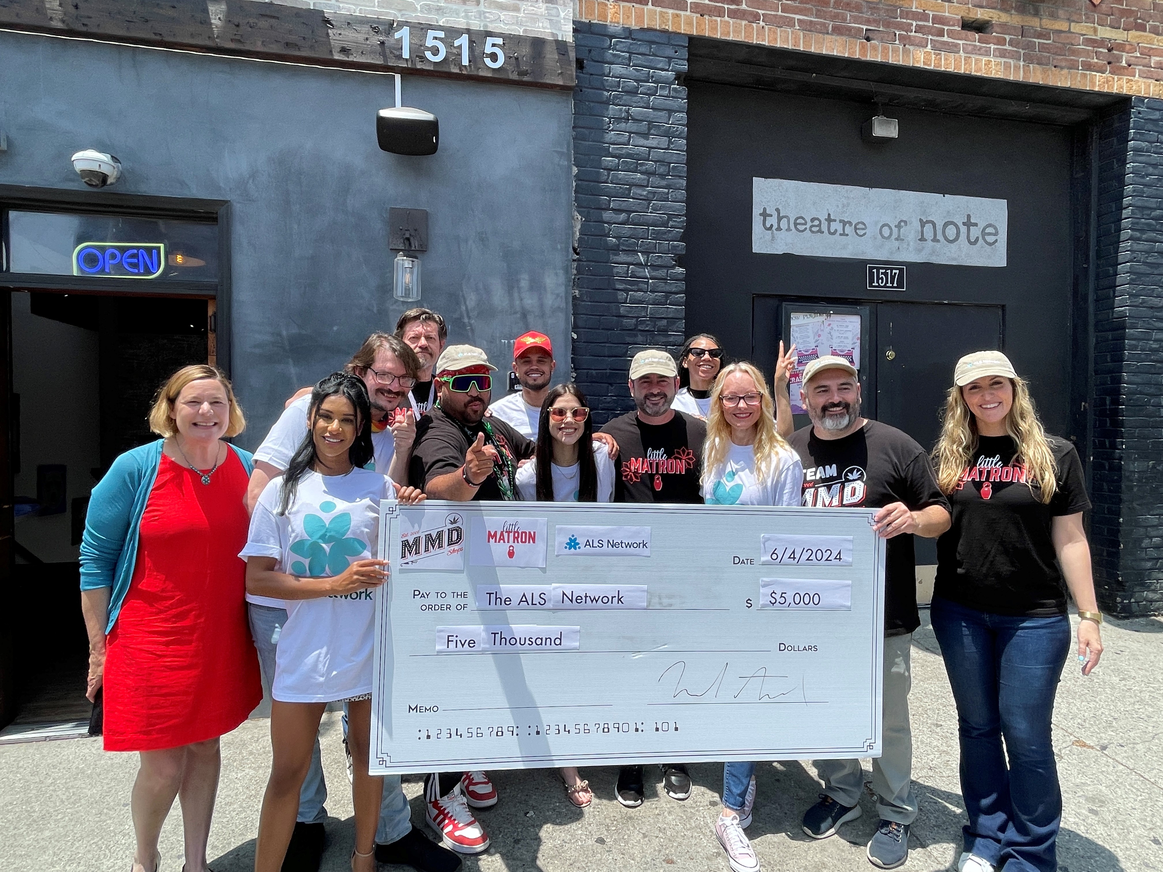 MMD staff and ALS Network representatives hold a $5,000 donation check outside MMD's Hollywood dispensary.