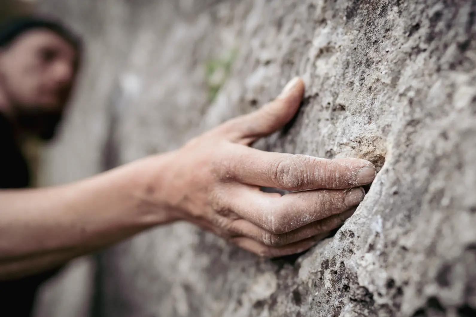 Adult male handholding on to a rock