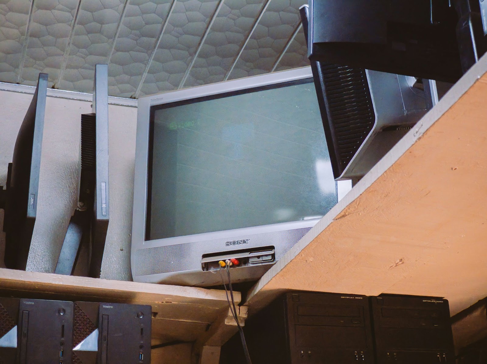 Simple room with multiple screens and basic media equipment, symbolizing the challenges churches face managing and displaying church content across different systems.
