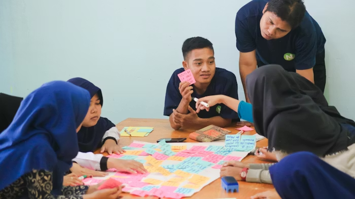 a smiling group of church volunteers collaborate with post-its on a poster.