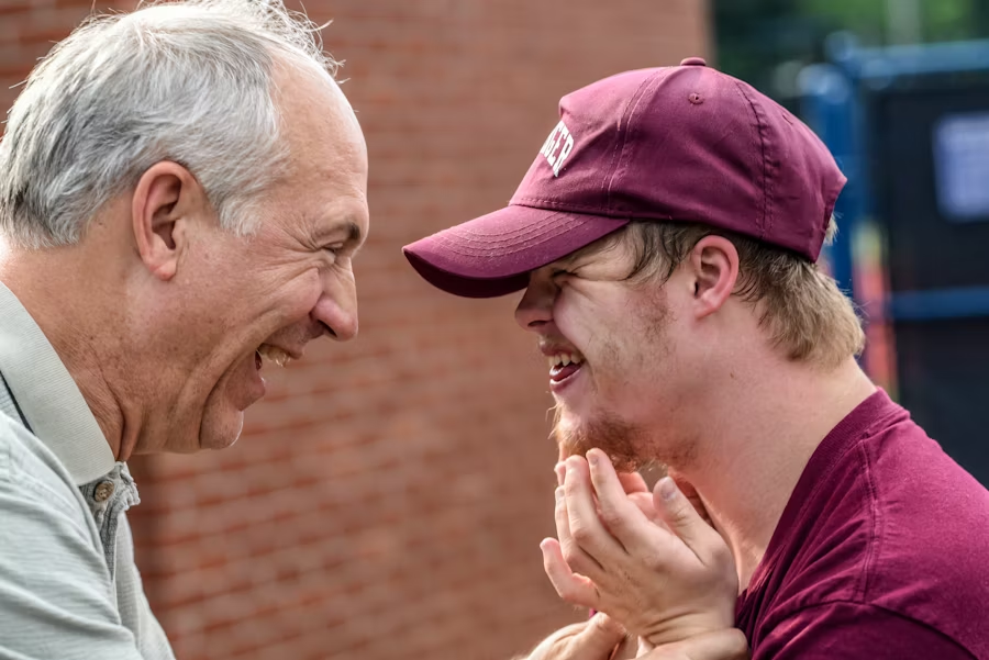 A church worker and a young man laugh together.