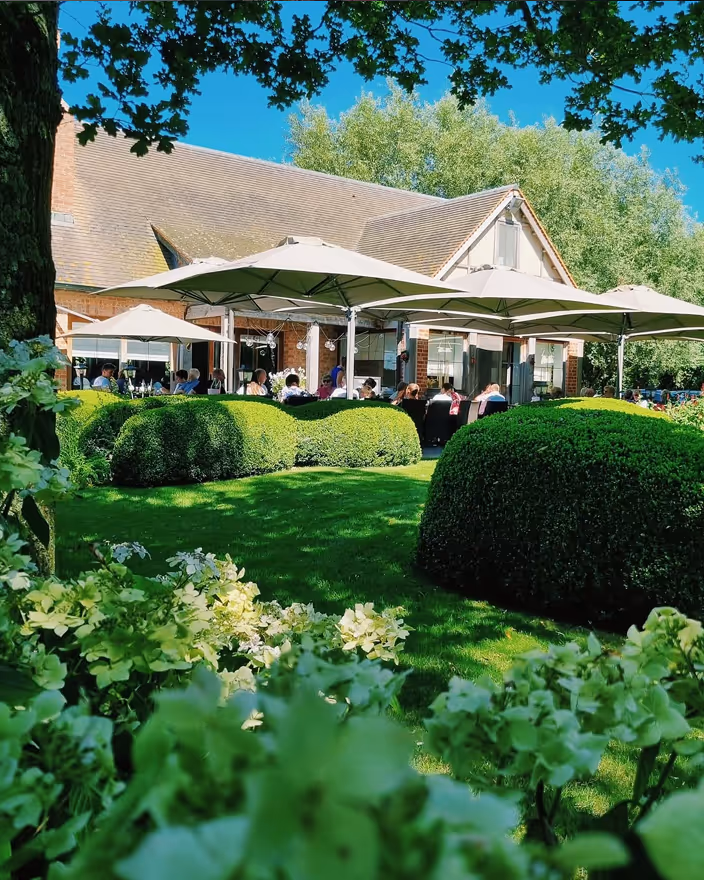 Buitenzicht van Restaurant d’Urville met groene tuin en terras in Torhout