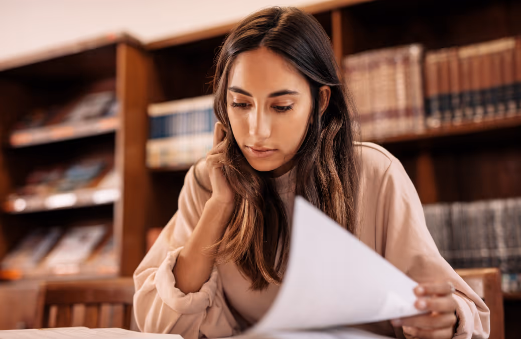 Photo of a student writing in the library