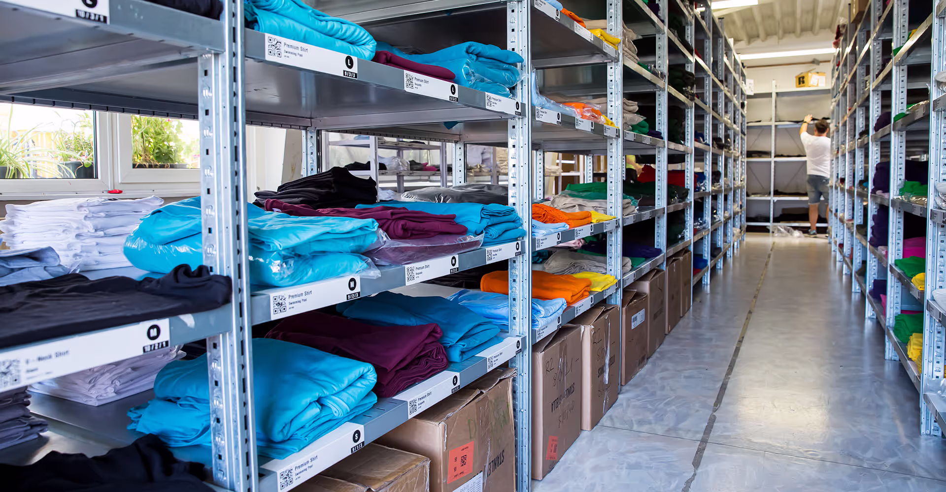 Gestapelte T-Shirts auf einem Lagerregal