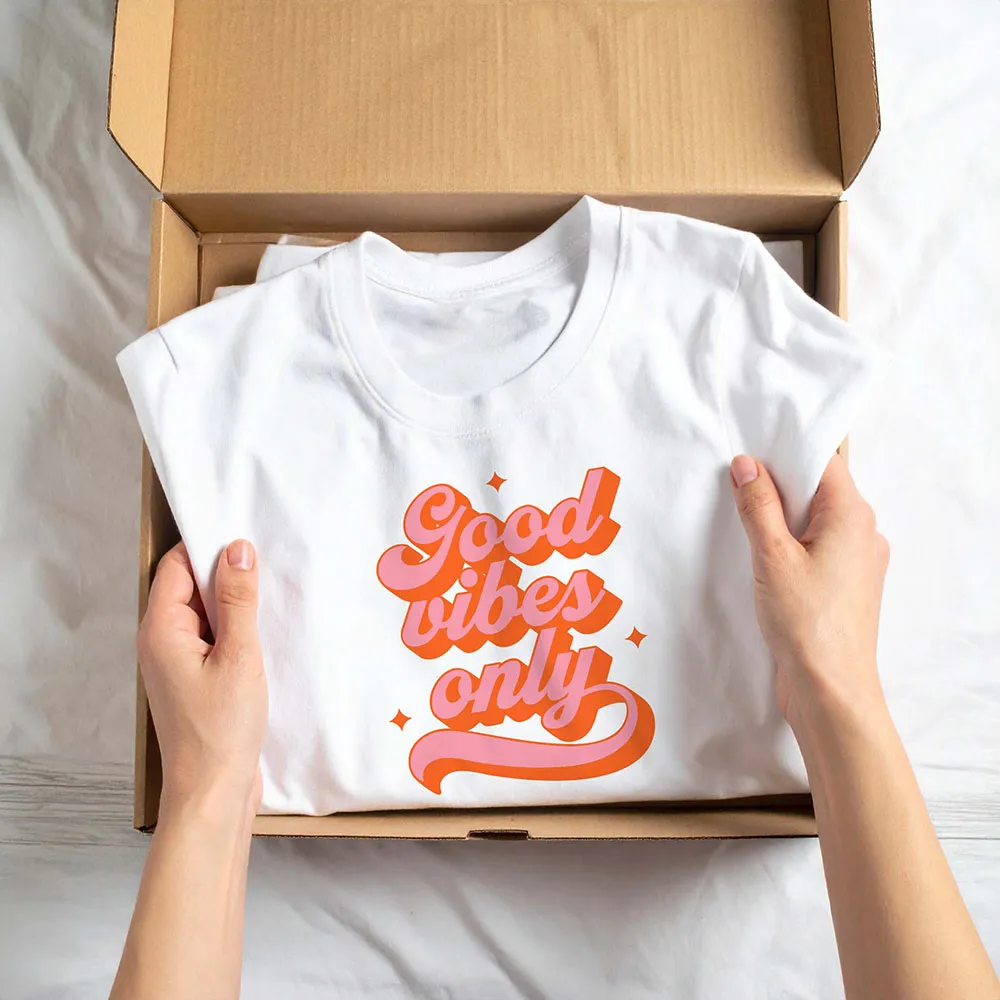 A person holding a box with a t - shirt in it.