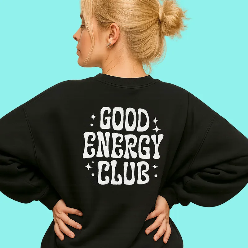 A woman wearing a black sweatshirt that says good energy club.
