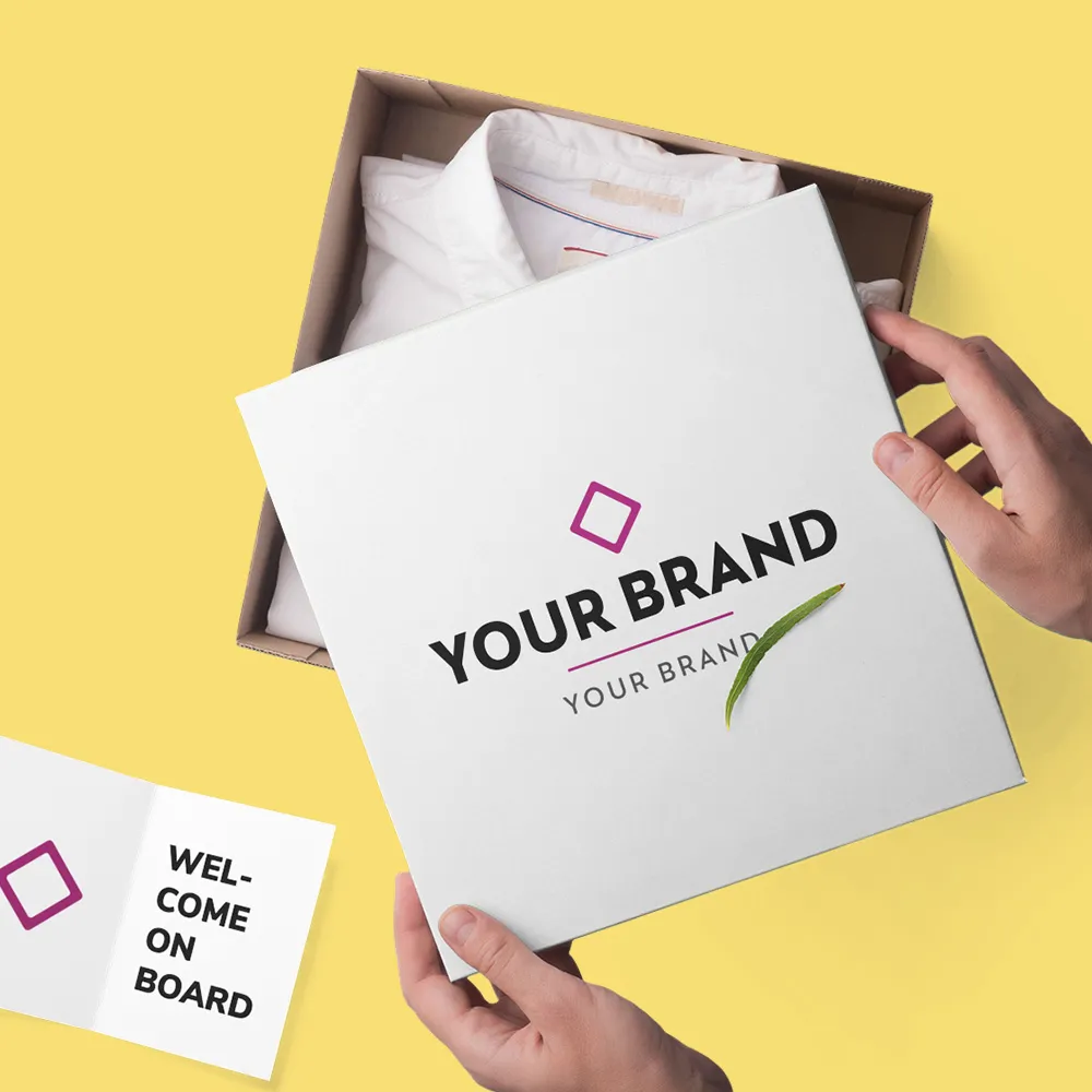 Hands holding a branded white box with a shirt inside and a welcome card on a yellow background.