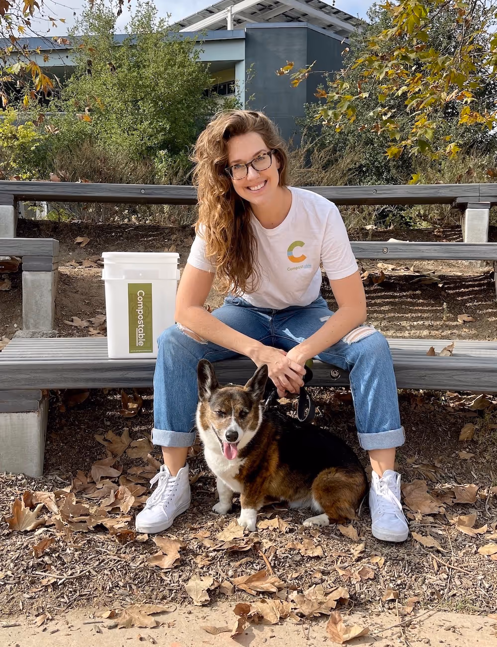 Monique and her dog sitting near compostable bin
