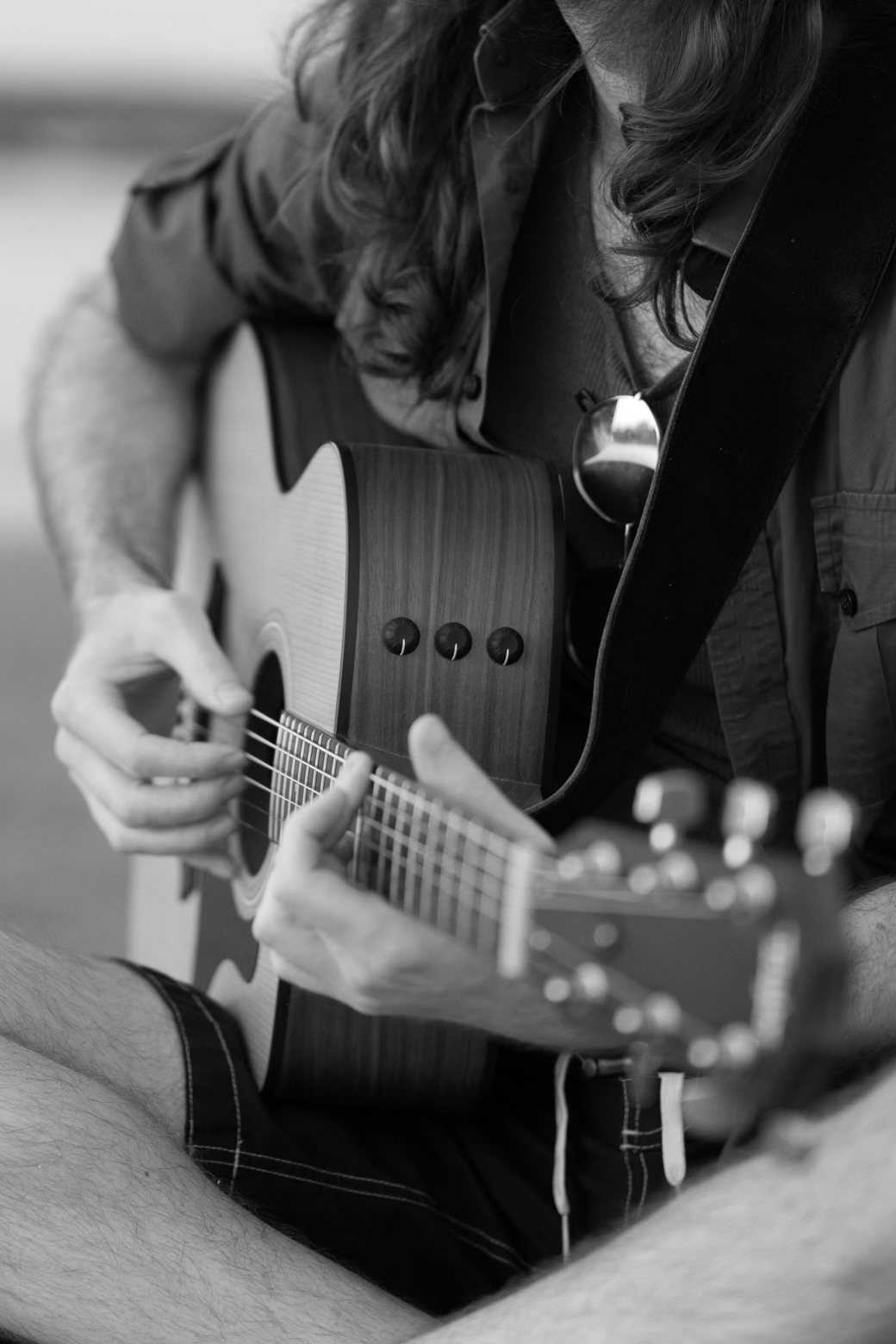 A close-up view of a steel-string acoustic guitar being played fingerstyle.