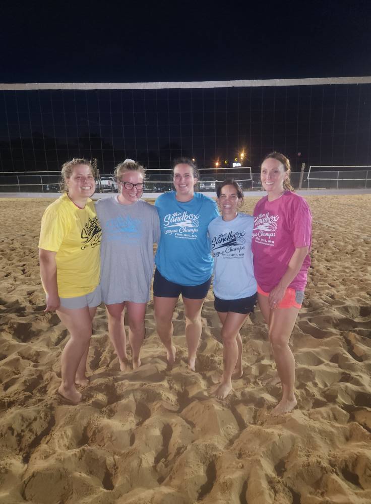 picture of a group of volleyball players wearing the sandbox volleyball logo t-shirts