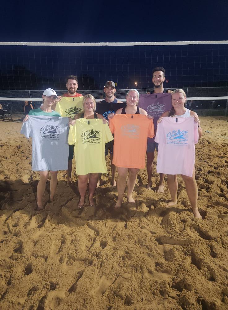 picture of a group of volleyball players wearing the sandbox volleyball logo t-shirts