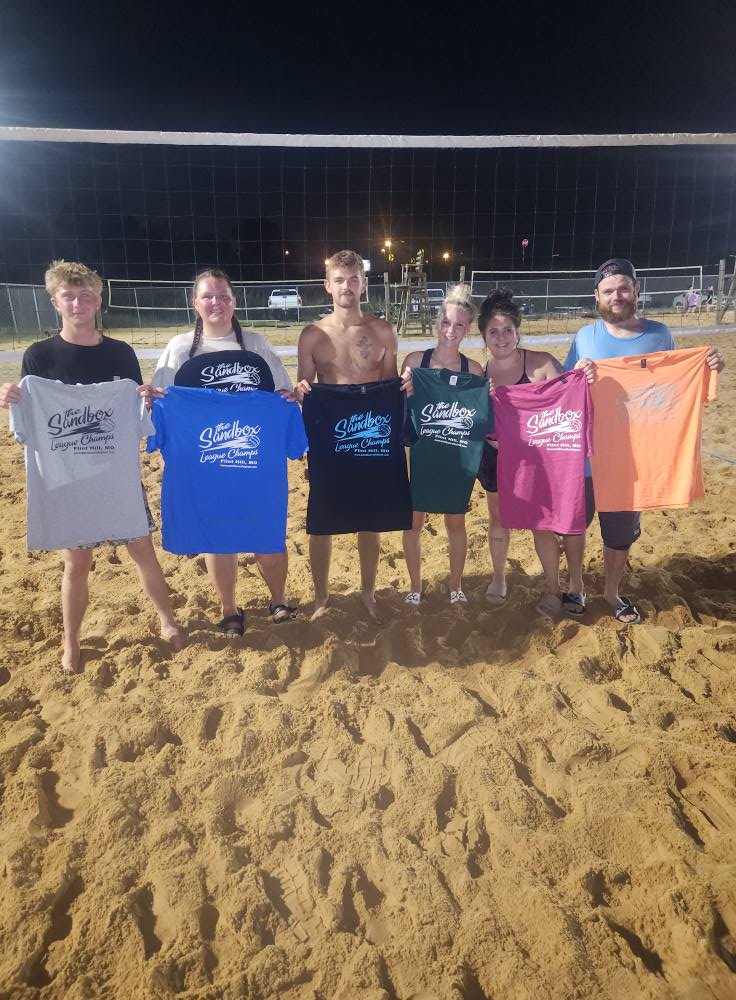 picture of a group of volleyball players wearing the sandbox volleyball logo t-shirts