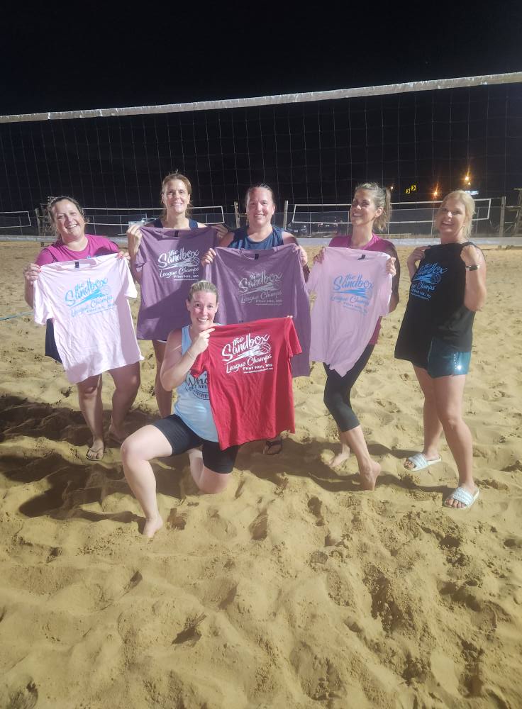 picture of a group of volleyball players wearing the sandbox volleyball logo t-shirts