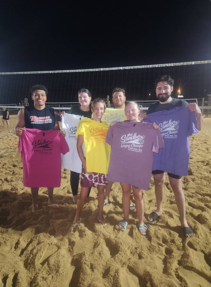 picture of a group of volleyball players wearing the sandbox volleyball logo t-shirts