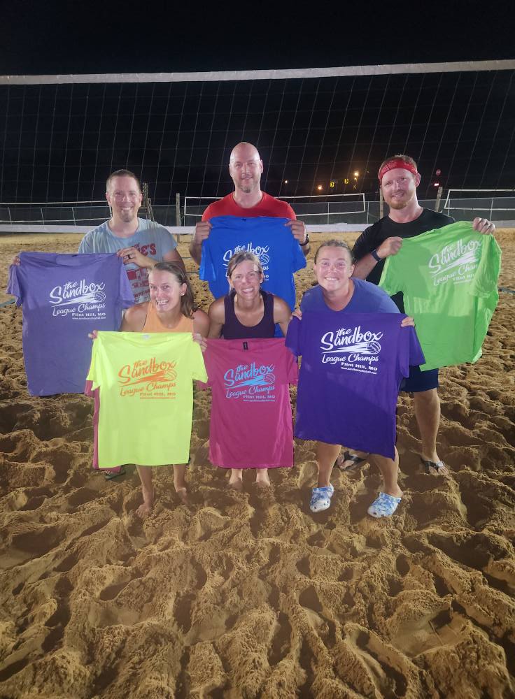 picture of a group of volleyball players wearing the sandbox volleyball logo t-shirts