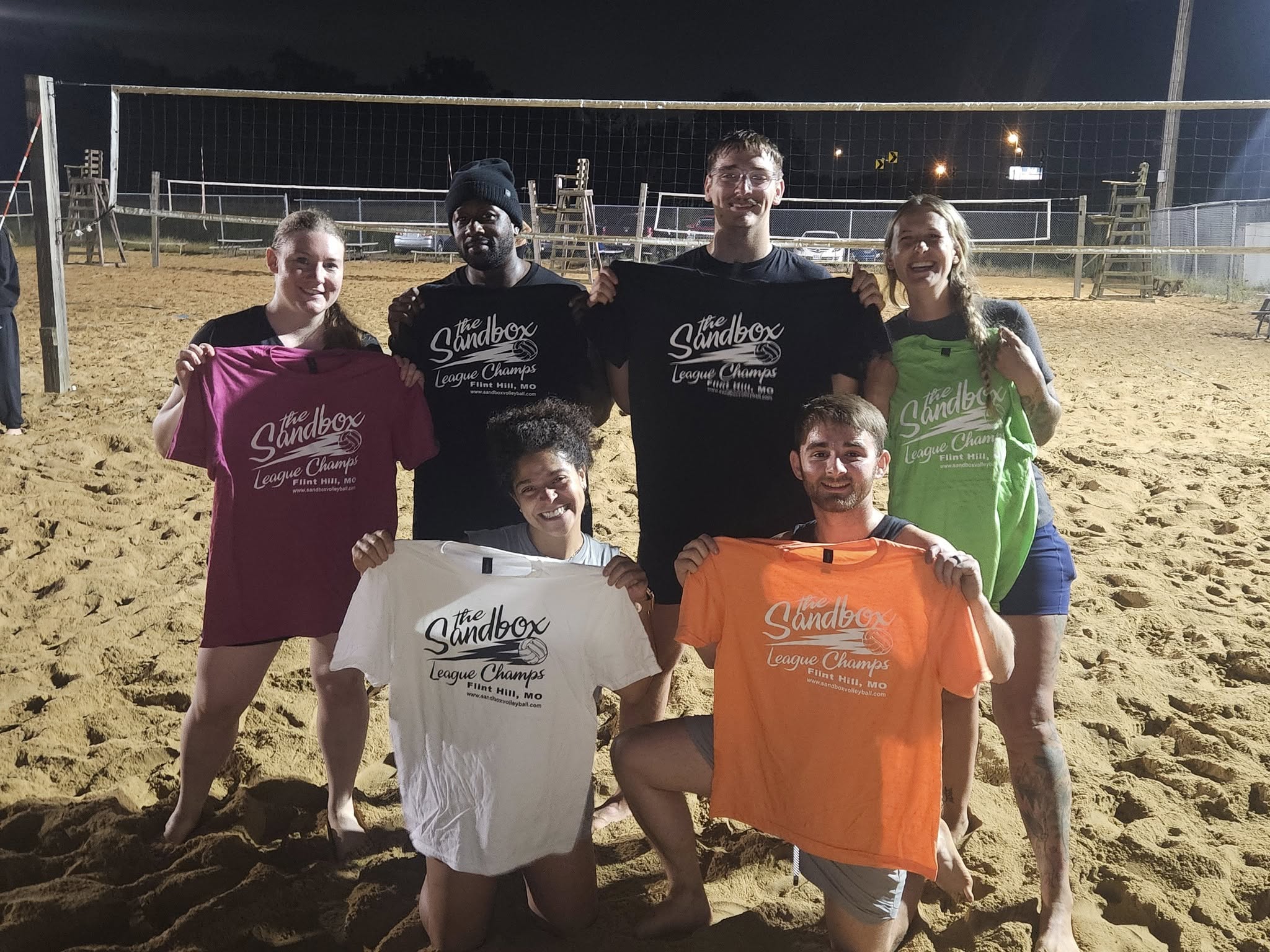 picture of a group of volleyball players wearing the sandbox volleyball logo t-shirts
