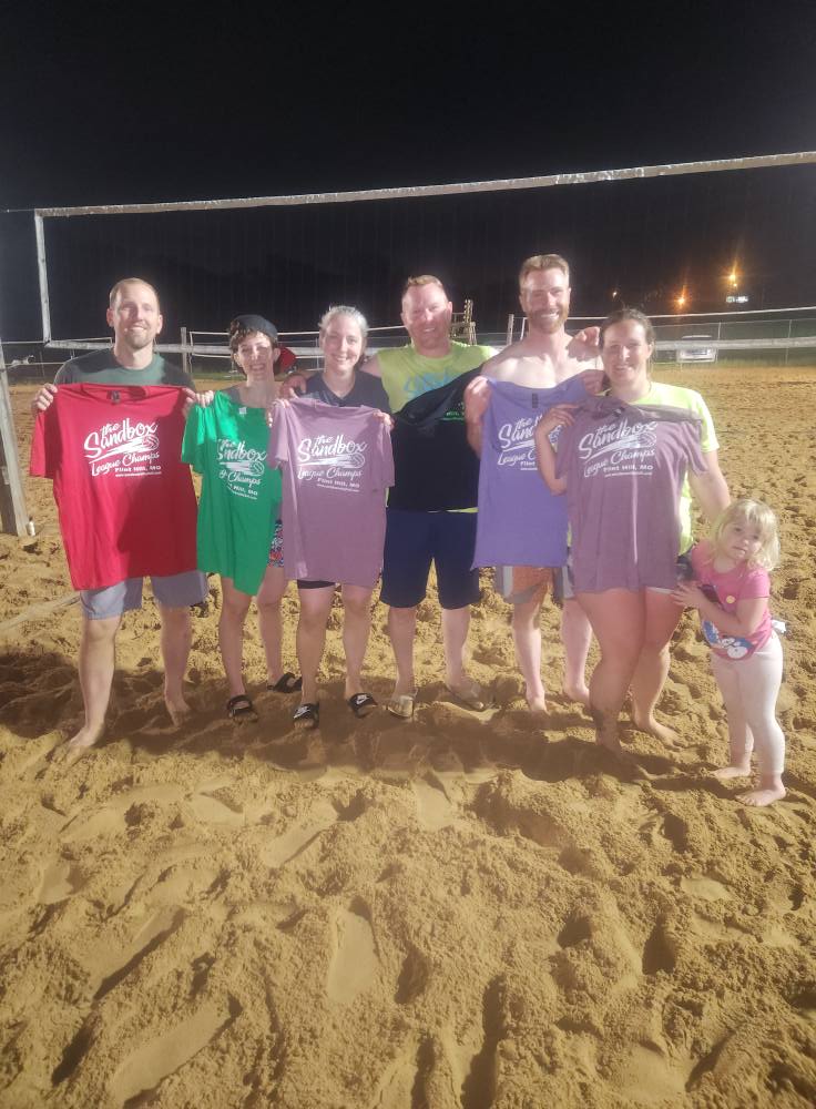 picture of a group of volleyball players wearing the sandbox volleyball logo t-shirts