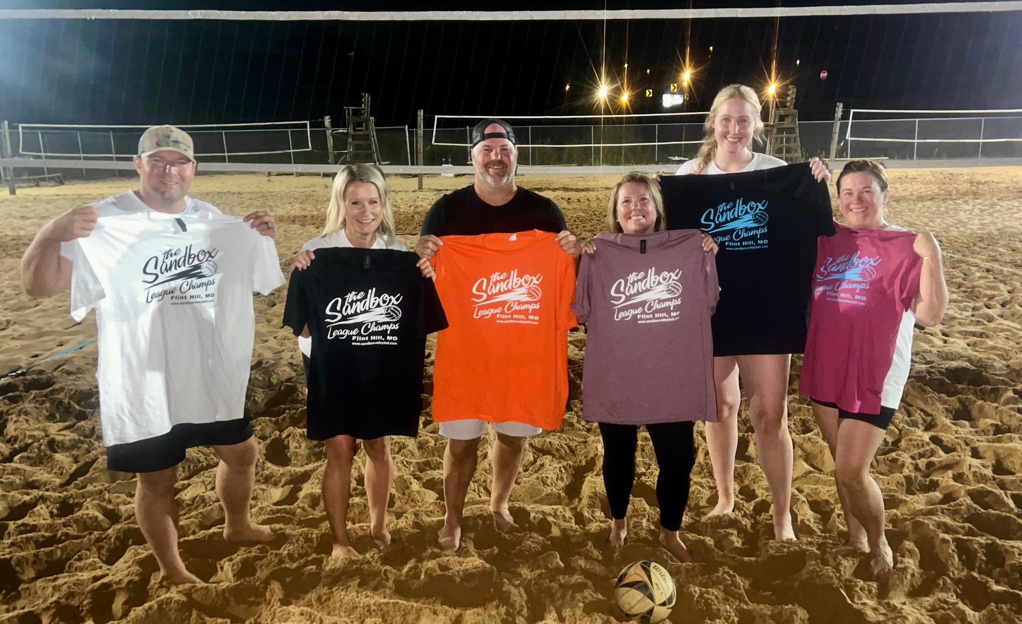 picture of a group of volleyball players wearing the sandbox volleyball logo t-shirts