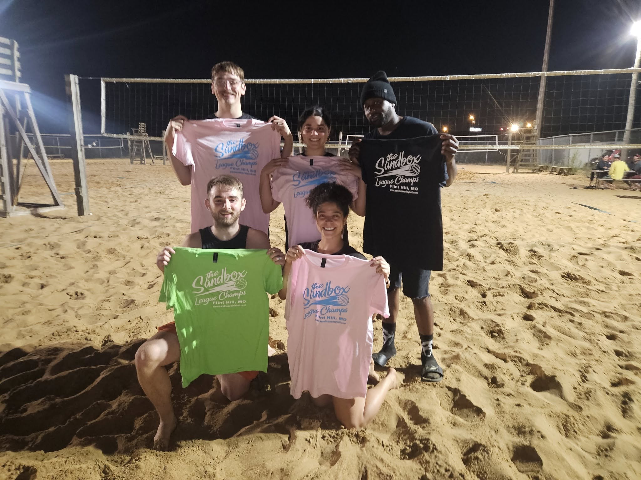 picture of a group of volleyball players wearing the sandbox volleyball logo t-shirts