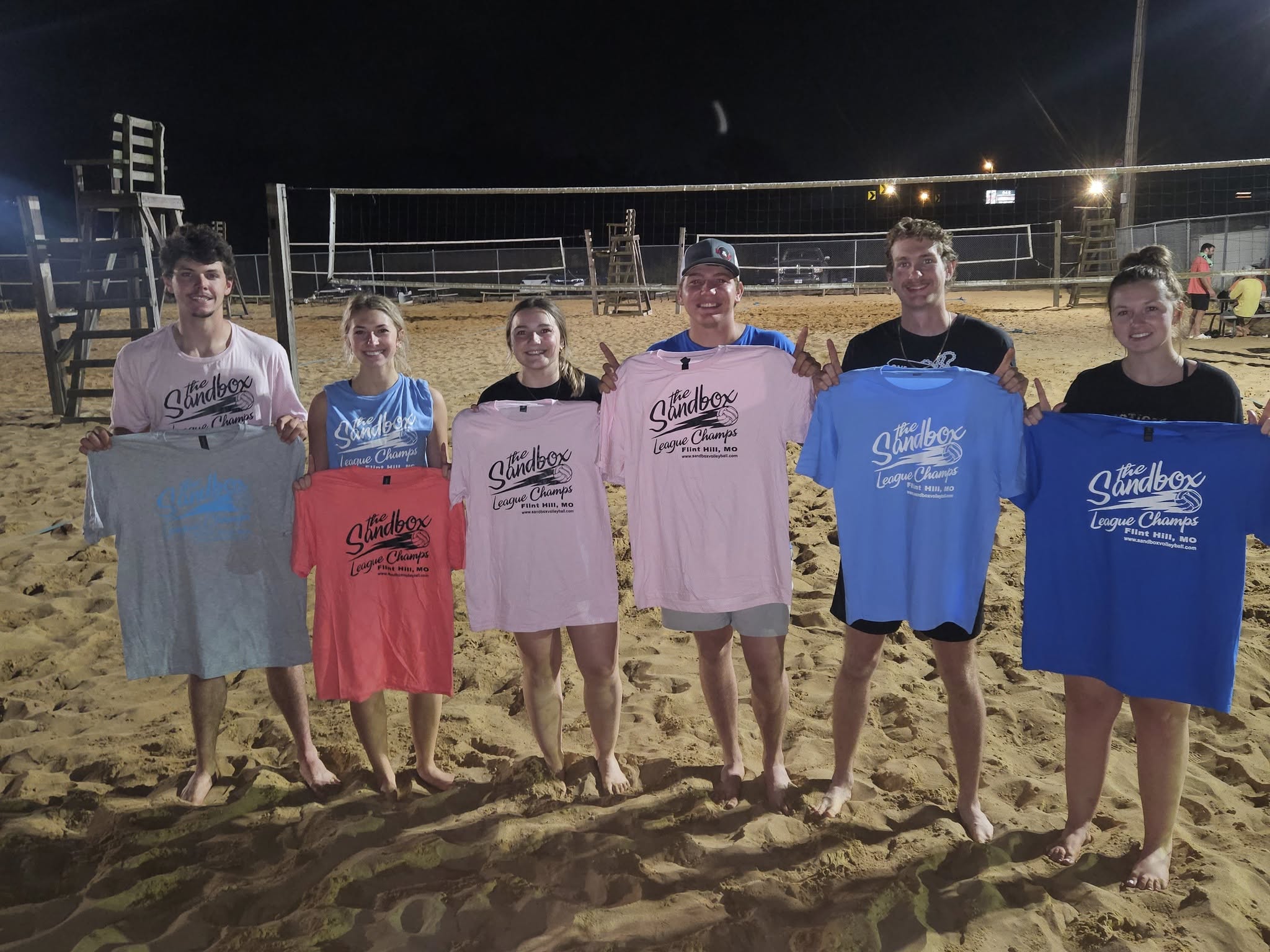 picture of a group of volleyball players wearing the sandbox volleyball logo t-shirts