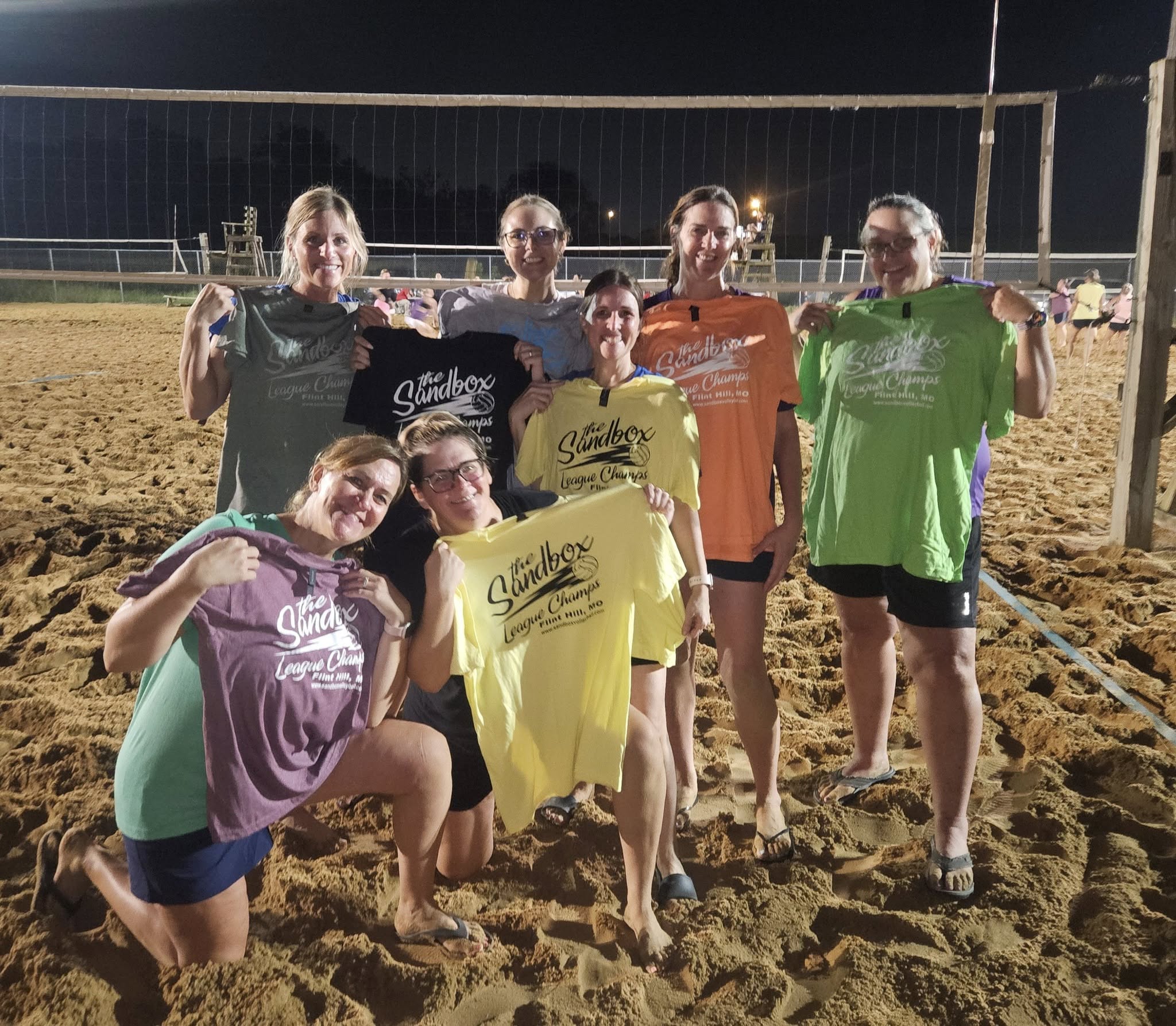 picture of a group of volleyball players wearing the sandbox volleyball logo t-shirts